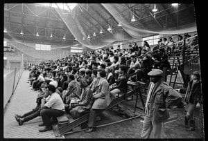 A mixed-race crowd on the bleachers in the Coolidge Cage